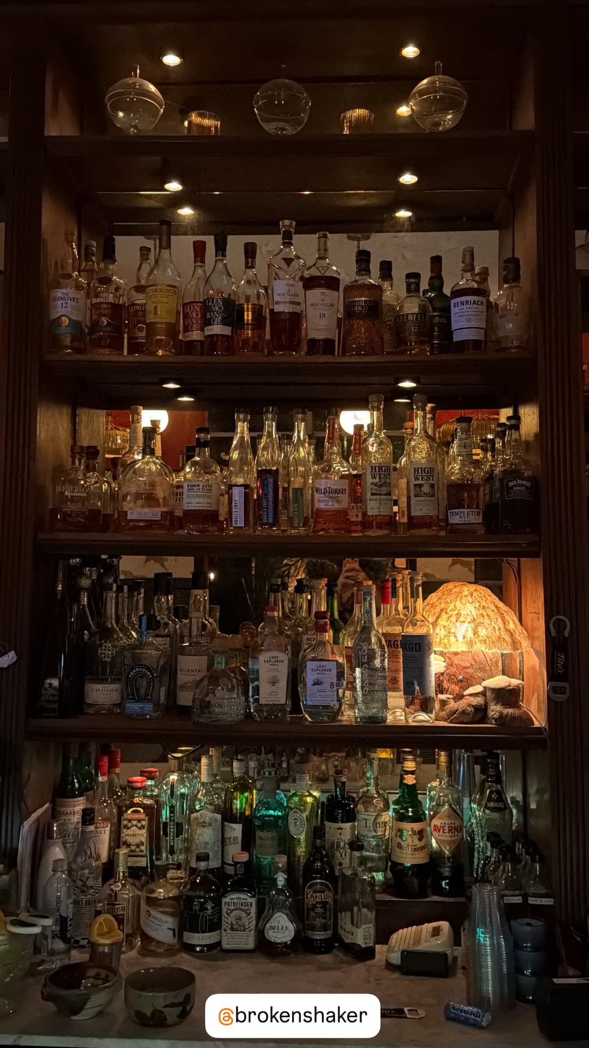 Broken Shaker bar shelf with various liquor bottles in Miami Beach