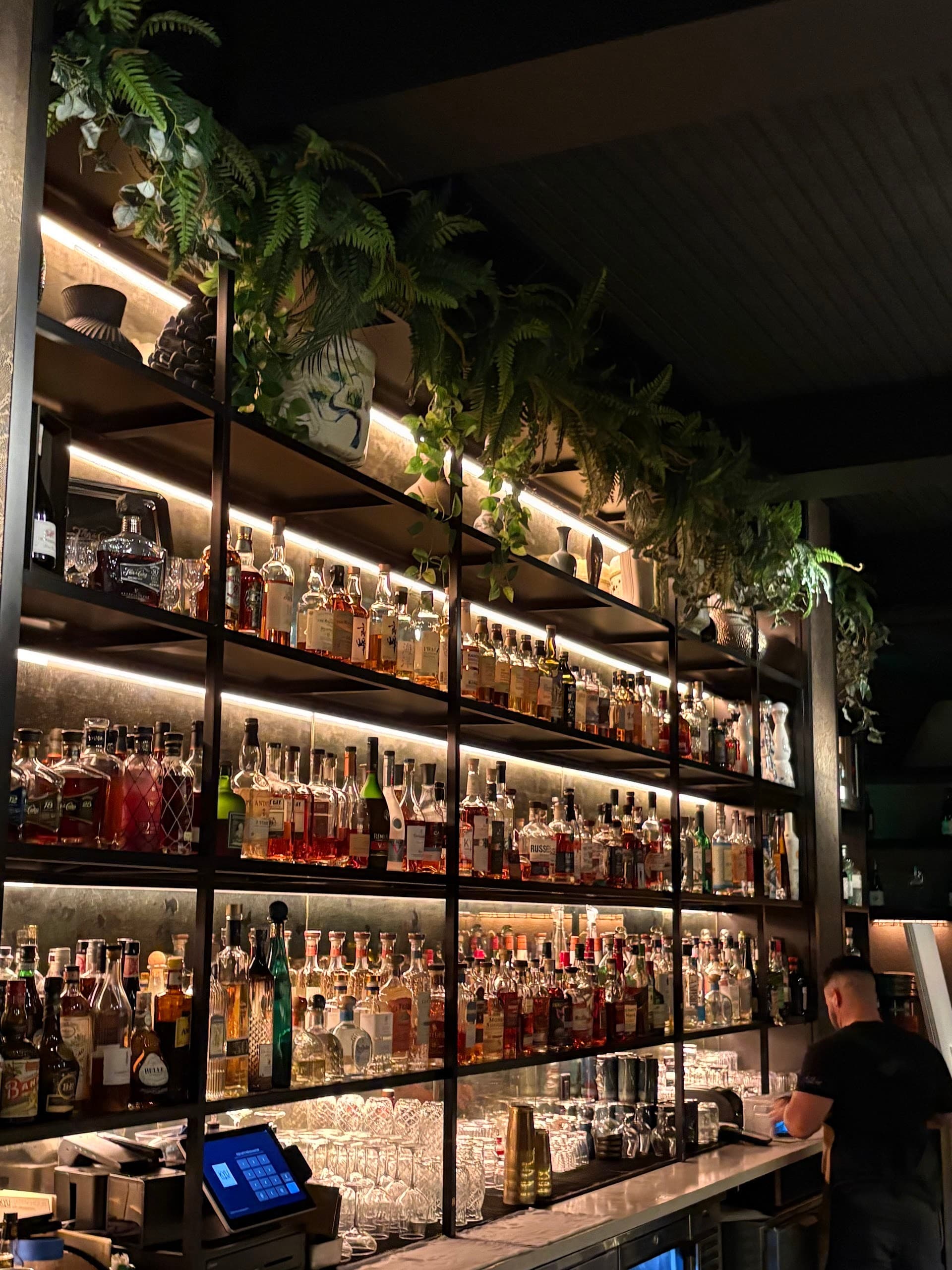 Bar area at KYU Miami featuring extensive liquor collection