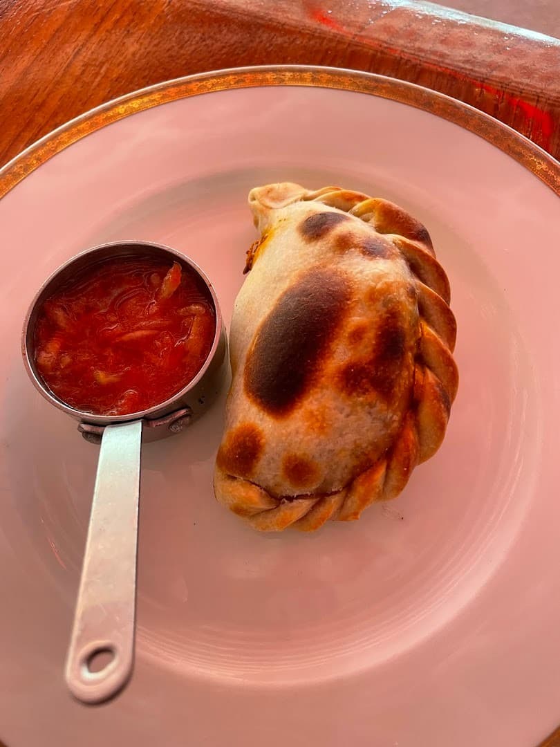 Delicious empanada with sauce at Los Fuegos by Francis Mallmann in Miami Beach