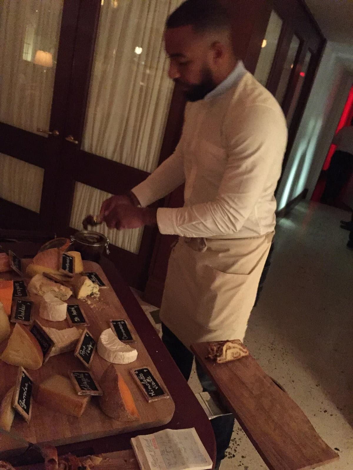 Staff member at Marion Miami preparing cheese selection