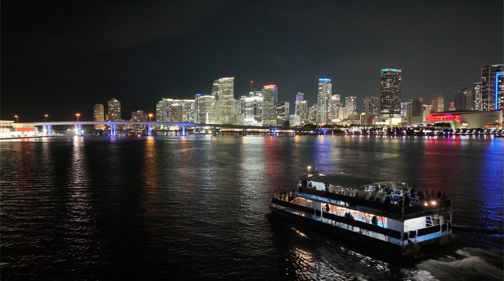 Miami skyline at night with cruise boat