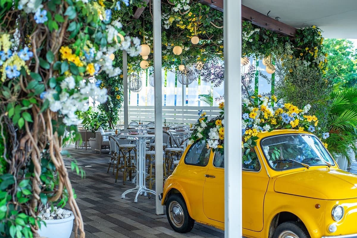 Motek Aventura restaurant interior with flowers and a yellow car