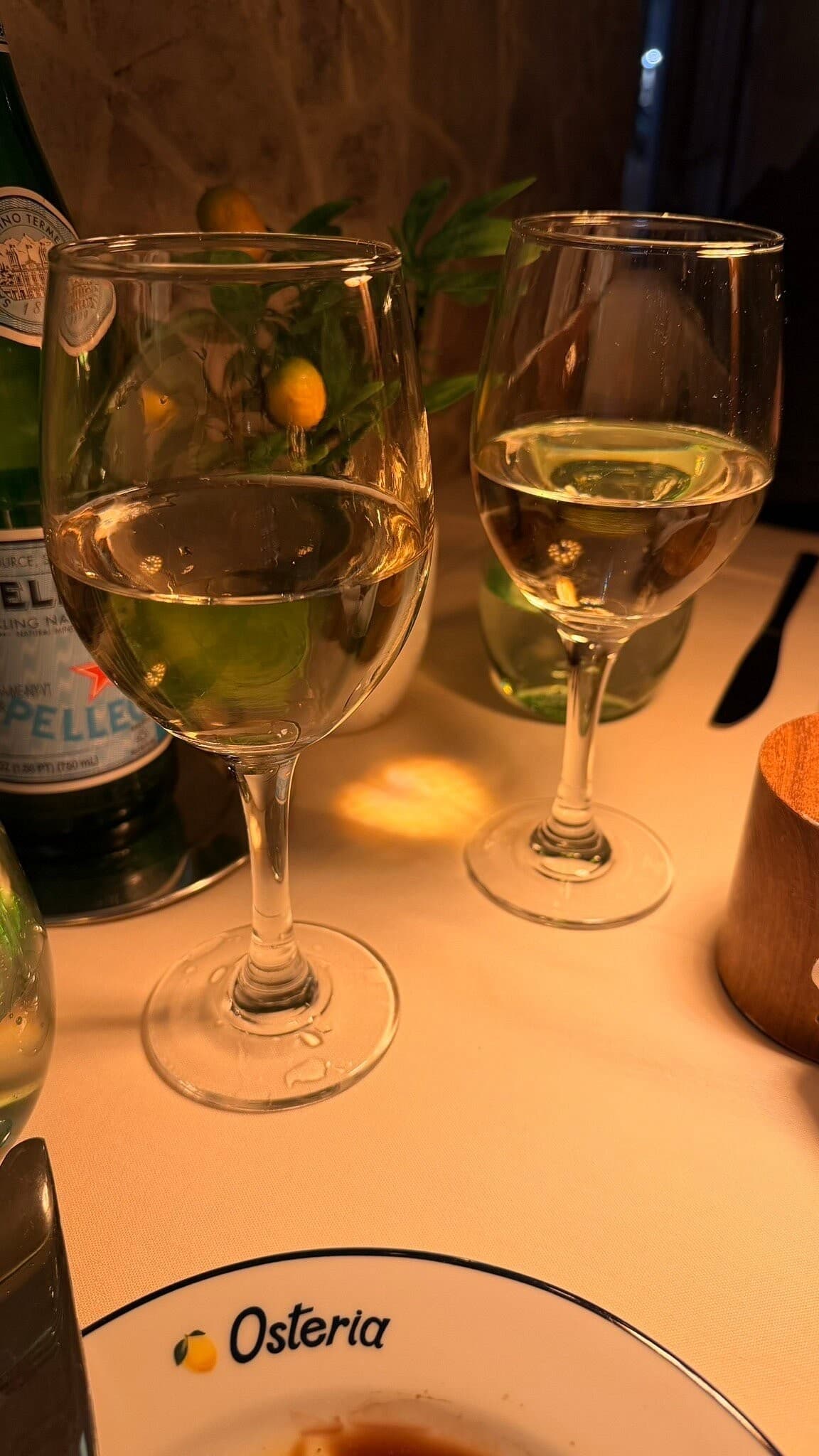 White wine glasses and a relaxed dining scene at Osteria Positano, Miami Beach