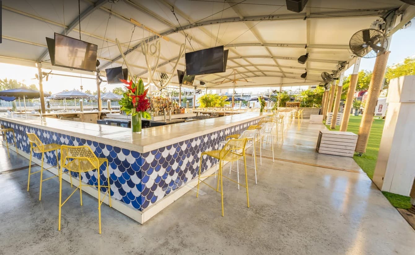 The Wharf Miami bar setup with golden chairs and blue decor