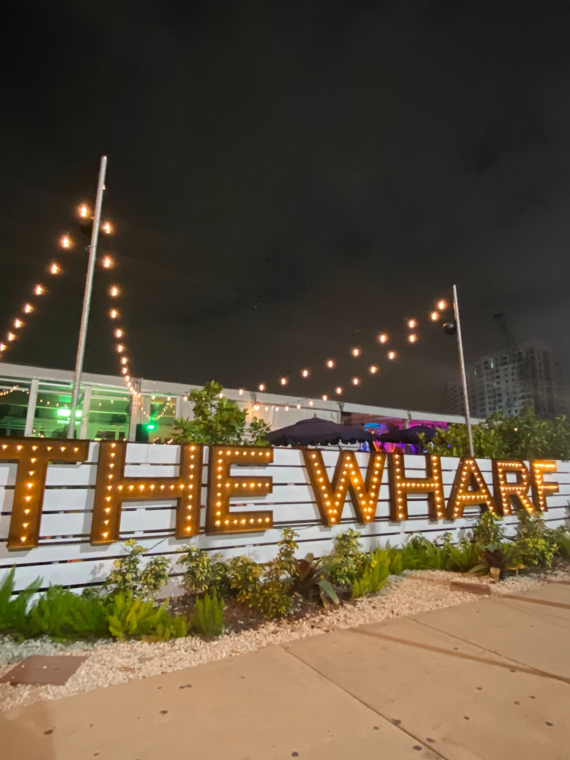 The Wharf Miami sign illuminated at night